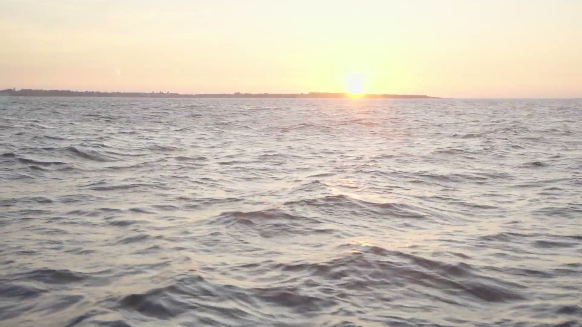 Open sea at sunset with the sun on the horizon
